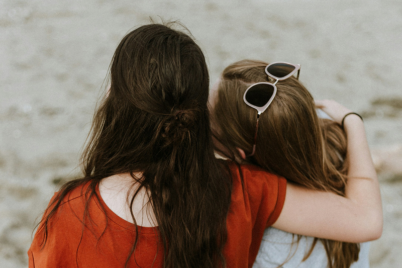 people sitting at beach hugging