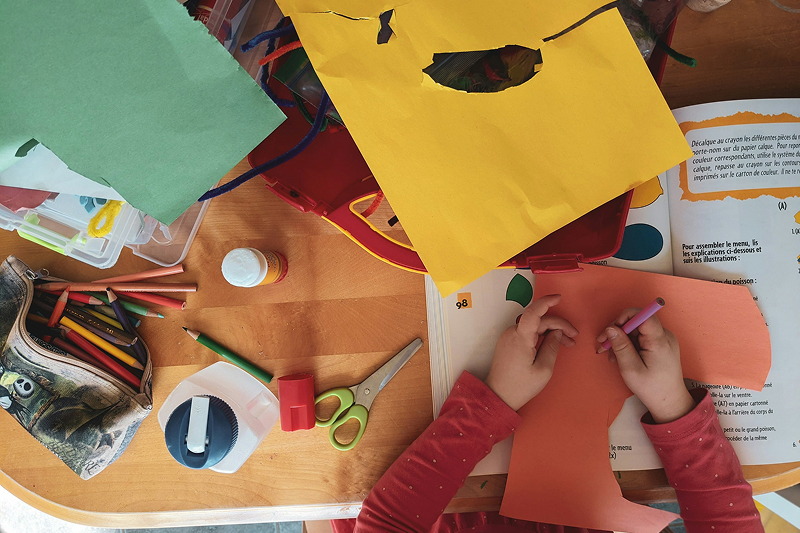 Child at table with arts and crafts